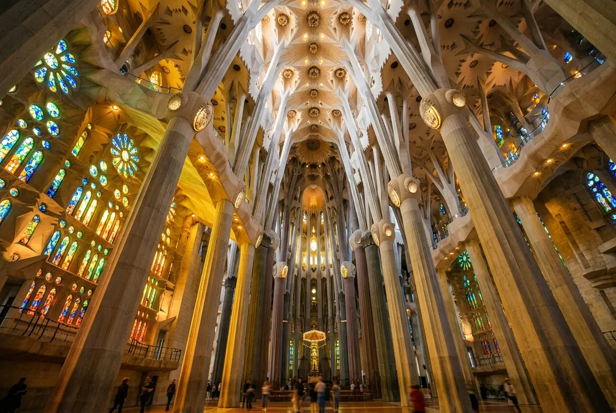 Upward angle photo previewing a sagrada familia inside tour, showing branching tree like columns and colored stained glass light washing across the nave